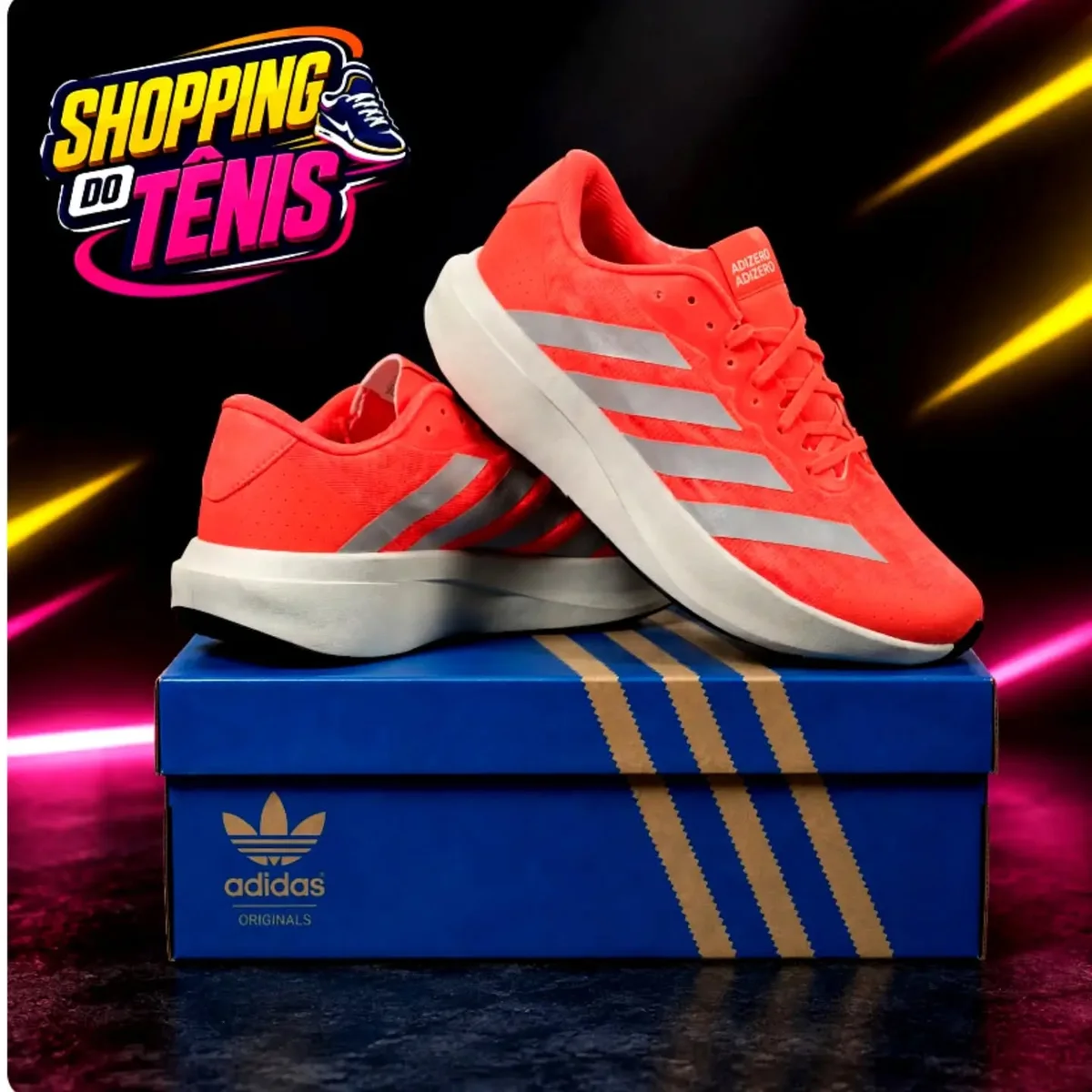 Adidas Adizero laranja em cima da caixa azul, no estúdio com o neon